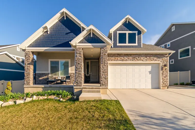 House with a stone front, garage and neatly kept lawn