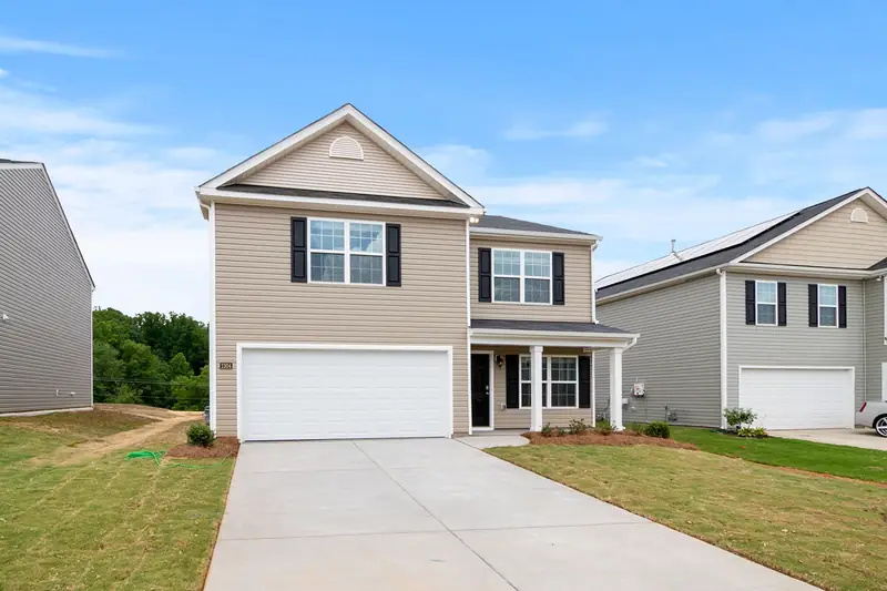Two-story house with a wide driveway and front lawn
